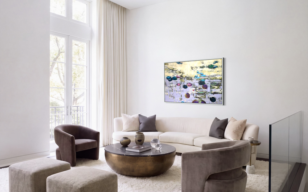 Exclusive horizontal water lilies fine art painting in a thin silver frame. The oversized canvas artwork is beautifully displayed in a bright modern penthouse on a white gallery wall above a premium curved boucle sofa and a luxury brass coffee table.