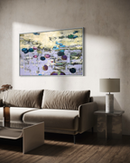 Modern luxury living room interior featuring an oversized purple water lilies canvas artwork in a silver frame. A premium velvet taupe sofa stands on rich dark hardwood floors under dramatic natural sunlight shadows next to a marble side table.